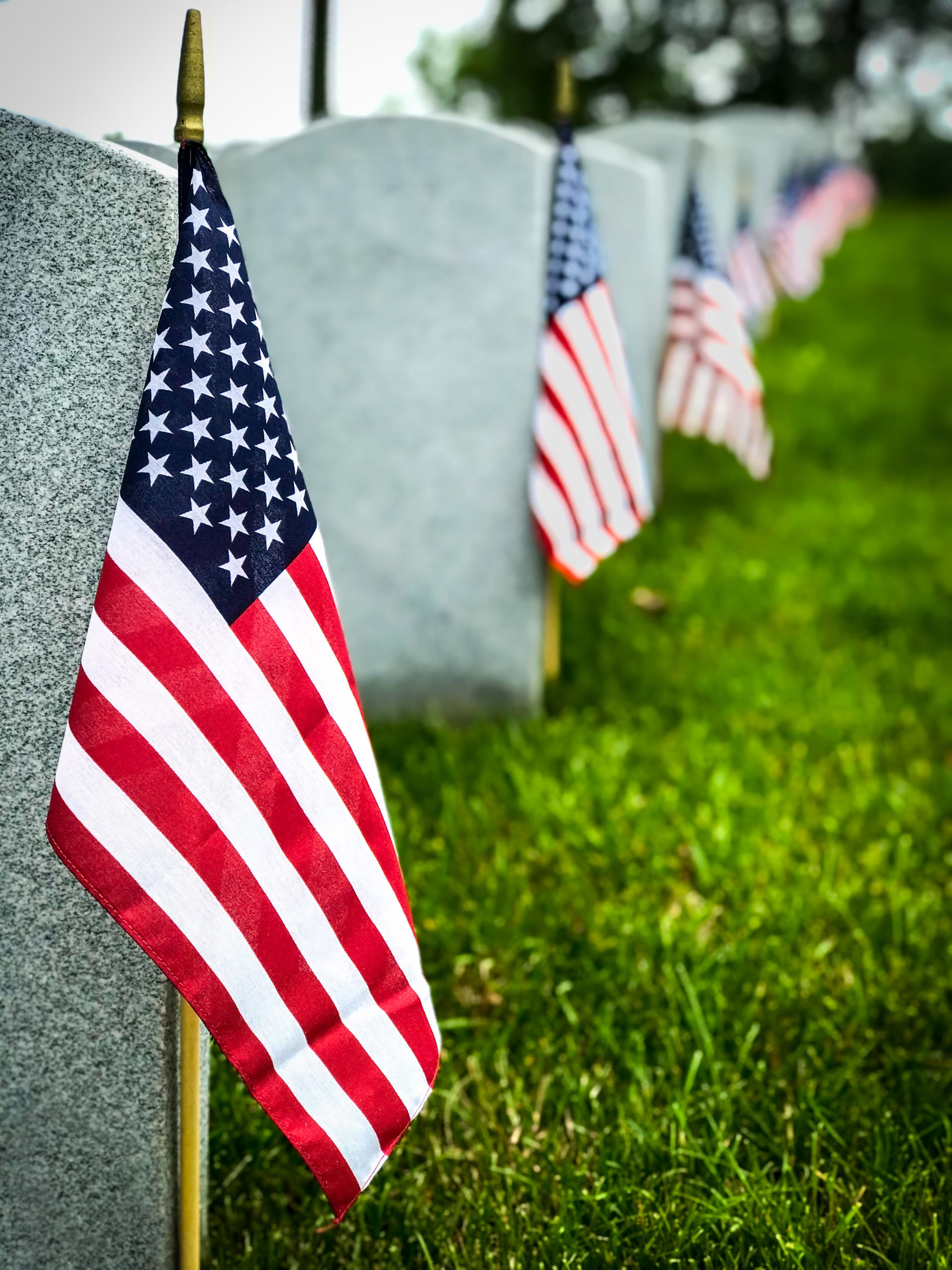 Decorated graves of US military service members at a cemetery.